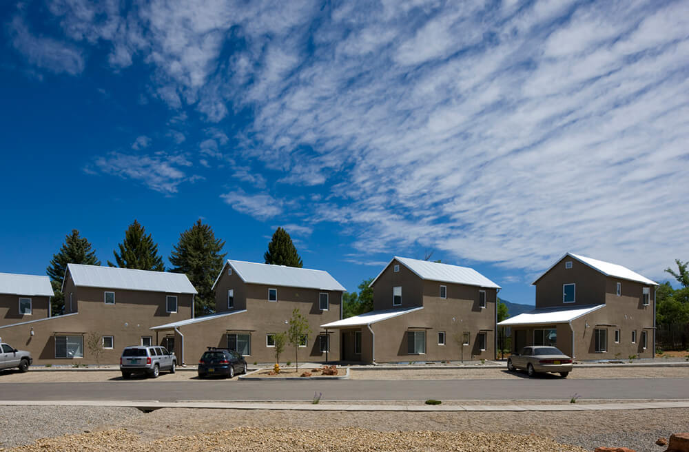 Row of detached two-story rental houses with white pitched metal roofs at Taos Haus, Taos NM