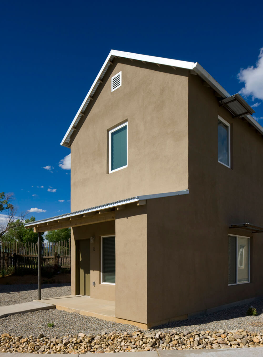 A single detached two-story house at Taos Haus under a deep blue sky
